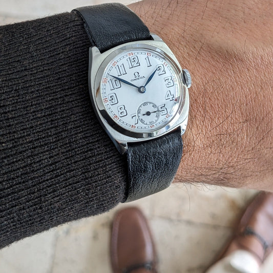 Close wrist view of Antique Omega Art Deco steel wristwatch with new black leather strap.