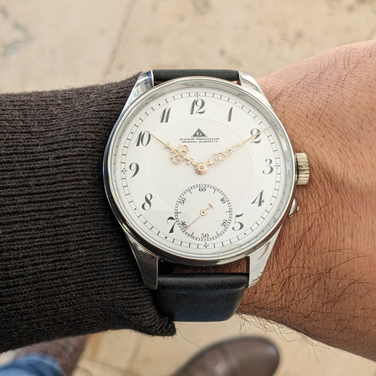 Deutsche Präzisionsuhr „Original Glashütte” का सामने का कलाई दृश्य, इसकी चमकदार केस, सफेद डायल, अलंकृत हाथ दिखाते हुए