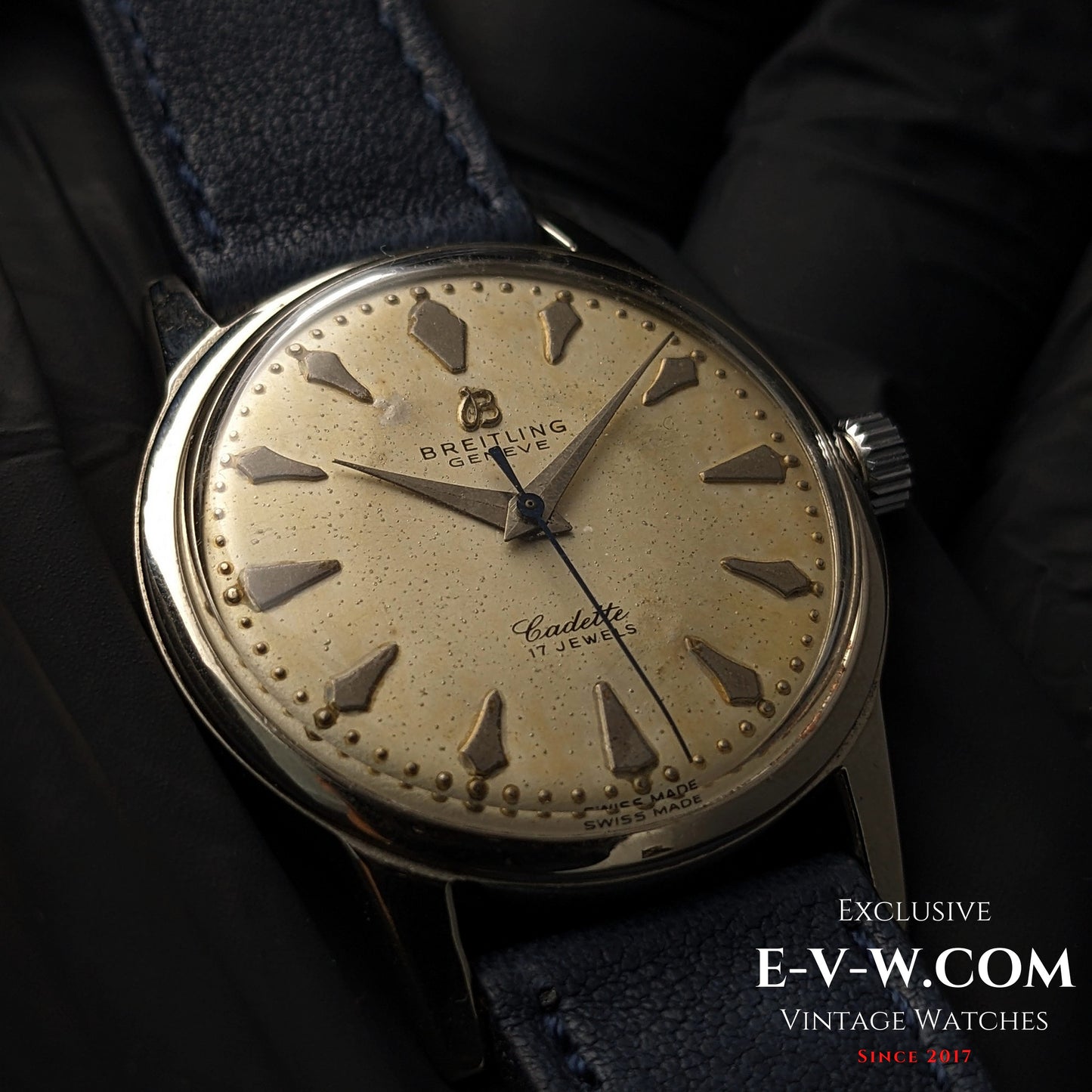 Vintage Breitling Geneve Cadette Watch 1960s with cream dial, triangular hour markers, and blue leather strap shown in close-up detail.