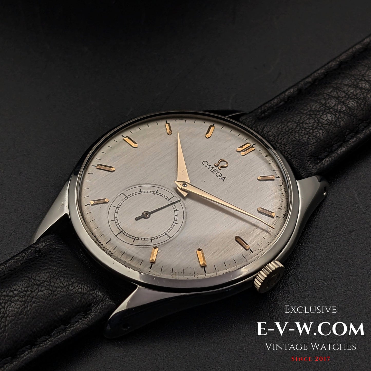 Close-up of Omega Jumbo 38mm Ref. 2505 20 vintage wristwatch with silver dial, gold indices, and sub-seconds, paired with a black leather strap.