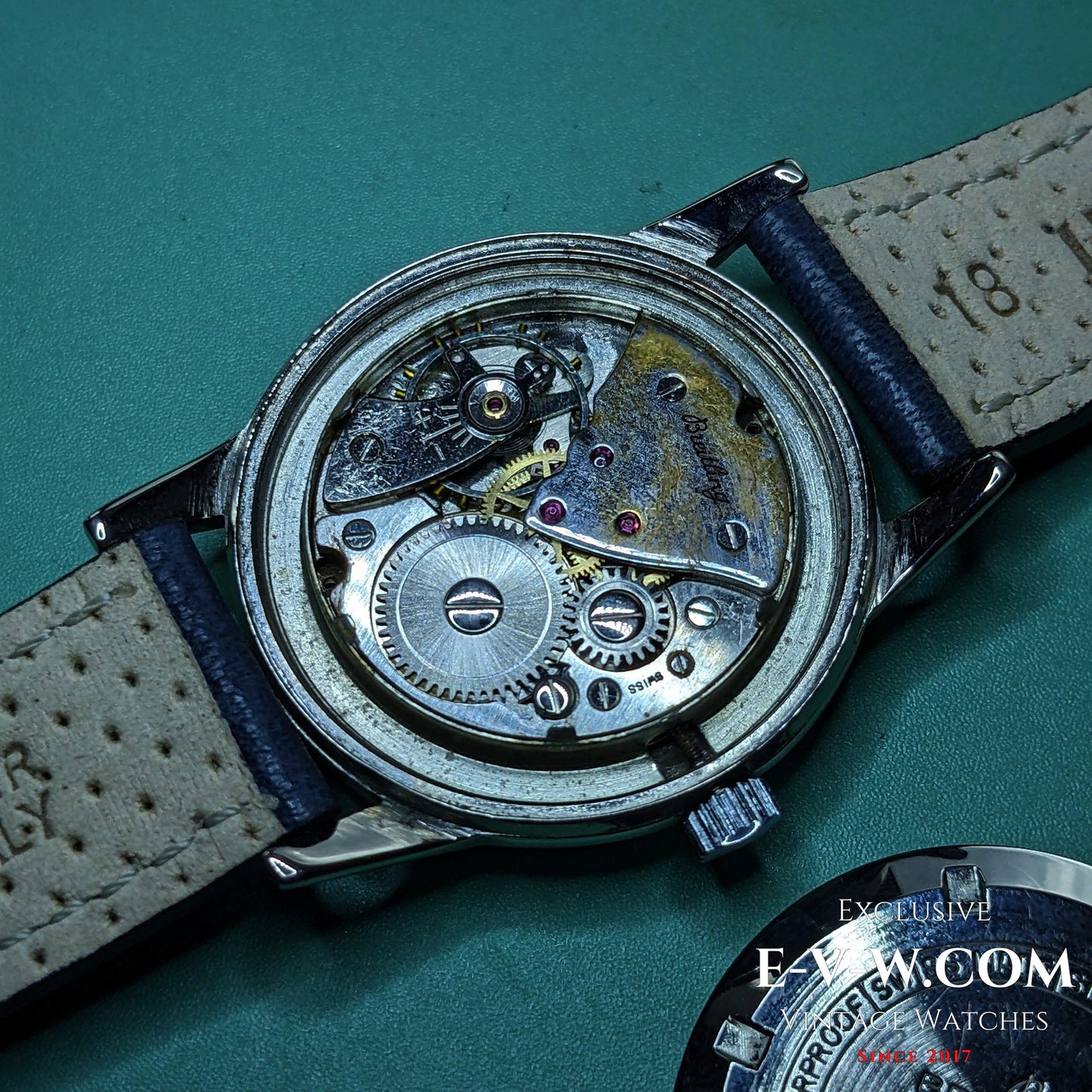 Exposed mechanical movement of Vintage Breitling Geneve Cadette Watch 1960s showing intricate gears and inner workings of the timepiece.