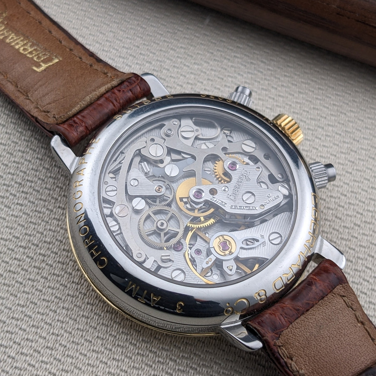 Eberhard & Co.. Godron Chrono reference 32031 shown from the back, with its mechanical movement visible through the round caseback and brown strap.