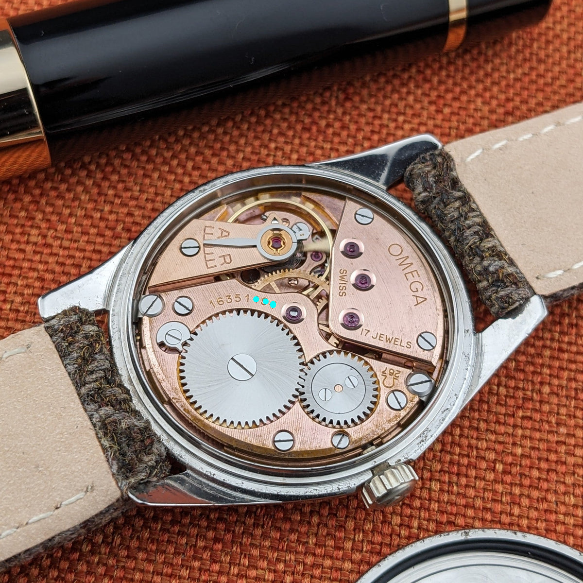 Omega Seamaster reference 29374 shown from the back with its exposed mechanical movement, engraved plates, jewels, gears and winding crown.