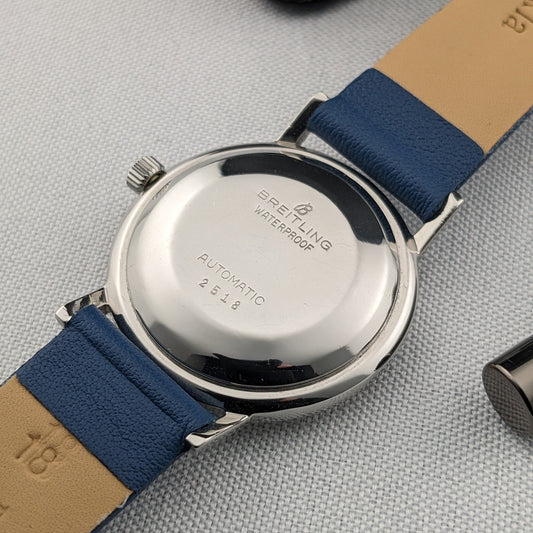 Breitling Automatic watch shown from the polished caseback, with visible Breitling, waterproof and automatic markings on a blue leather strap.