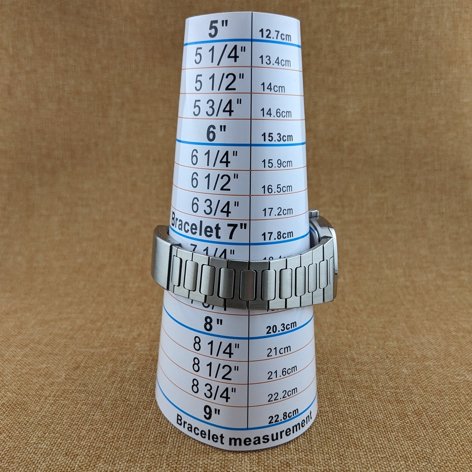 Omega Seamaster reference 196.0166 shown on a printed bracelet measurement guide, with the stainless-steel bracelet wrapped around the scale.
