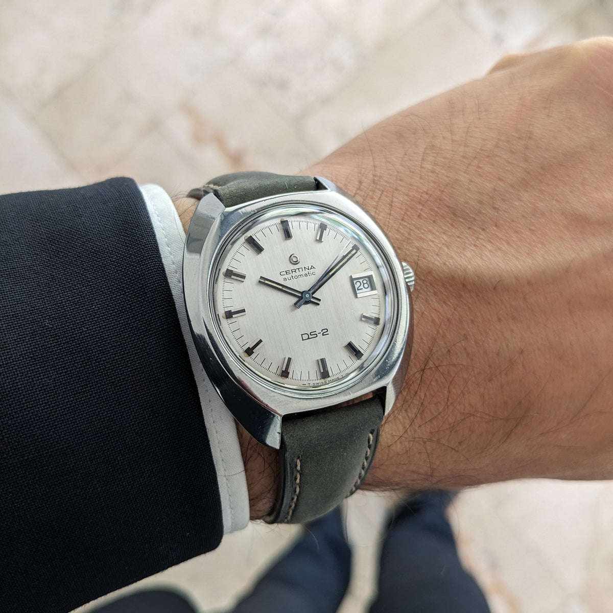 Certina DS-2 Automatic reference 5801 300 on a wrist, showing a silver dial, baton markers, date window, and dark stitched strap.