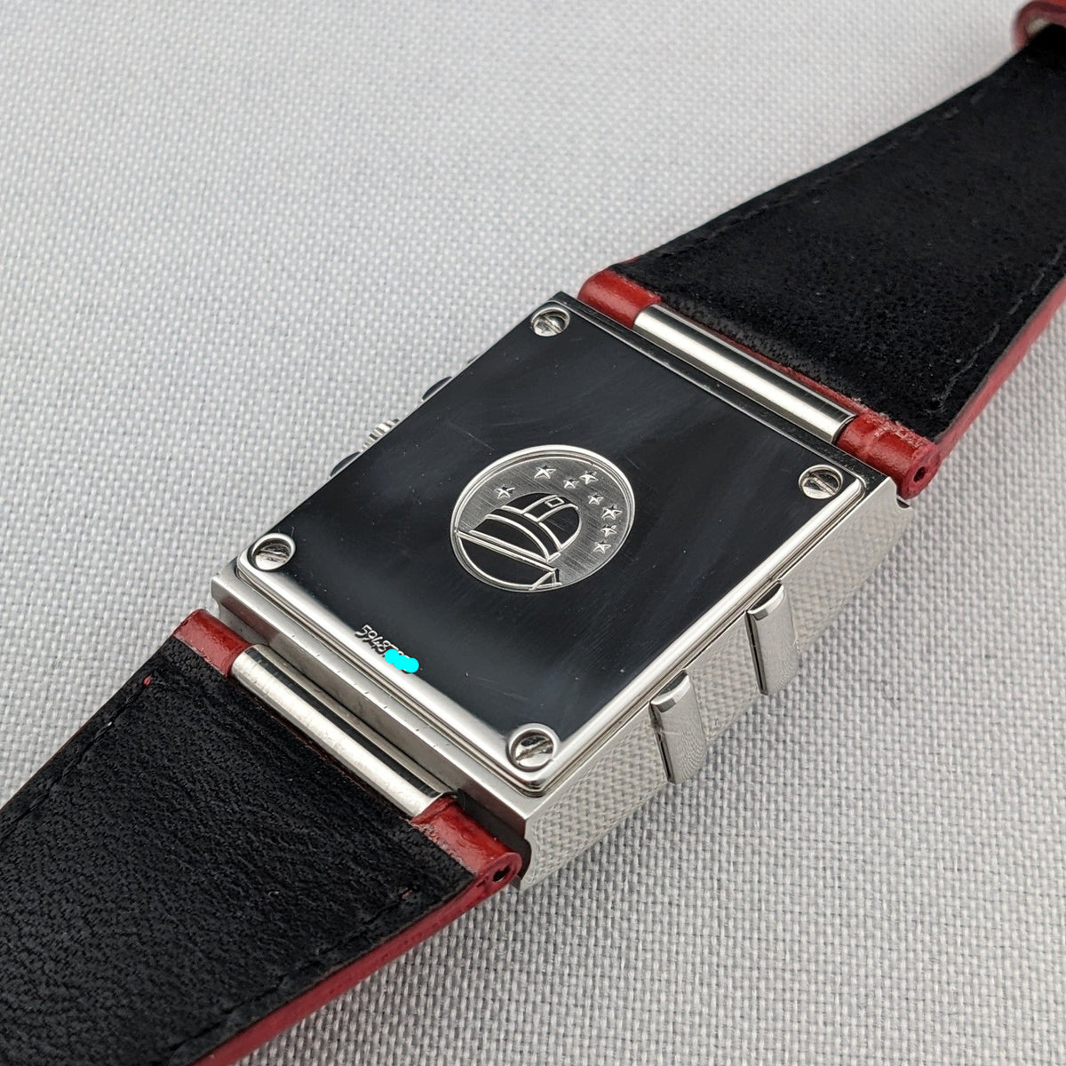 Rear view of the Omega Constellation Quadra 1841.73.31 showing its rectangular back, circular emblem, screws, and black-and-red strap.