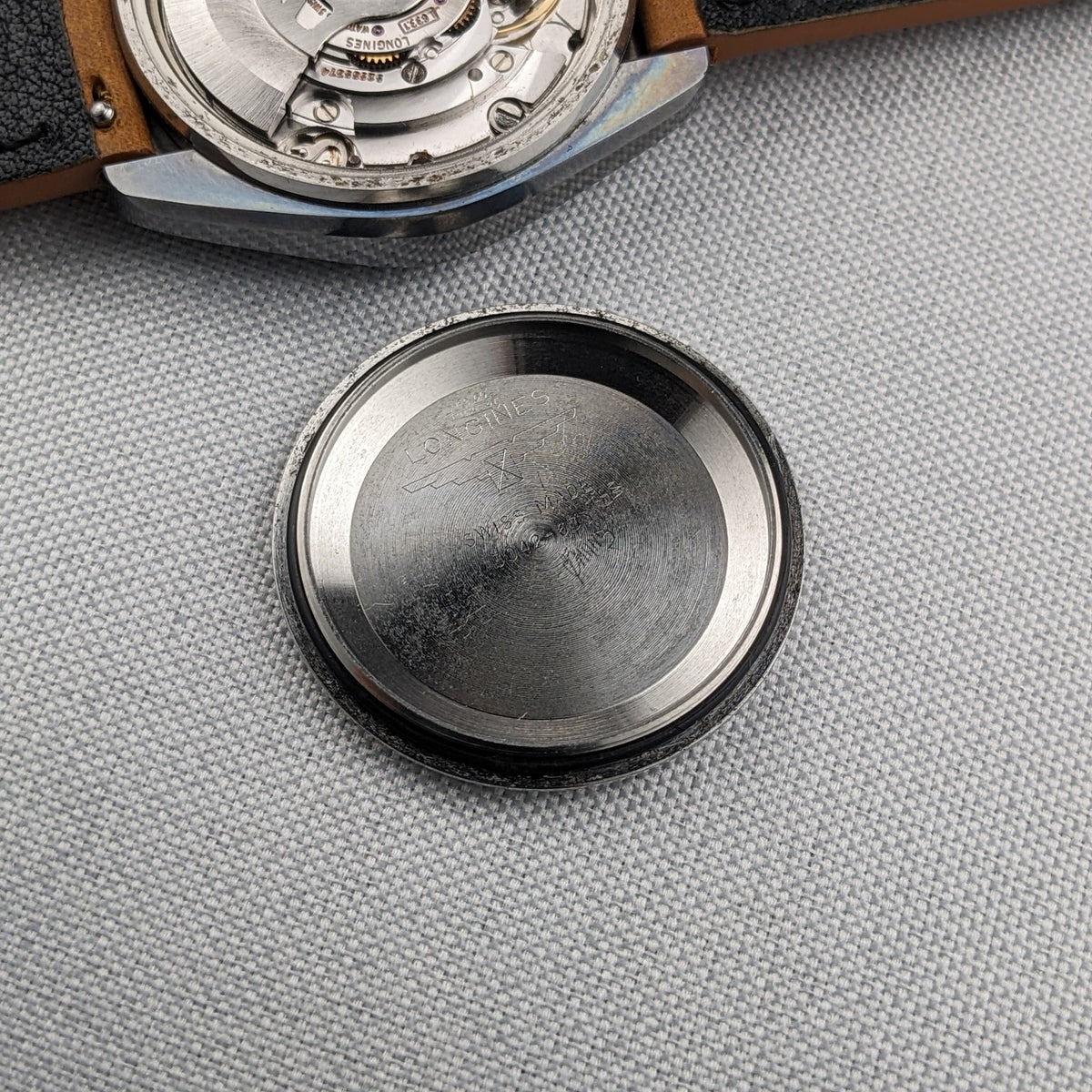 Open LONGINES Automatic reference 3042-633 showing the movement at top and the detached engraved caseback below.