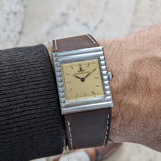 Close view of the Jaeger-LeCoultre Vogue Tank ref. 9120 on a wrist, showing its textured gold-tone dial and stepped silver-tone case.