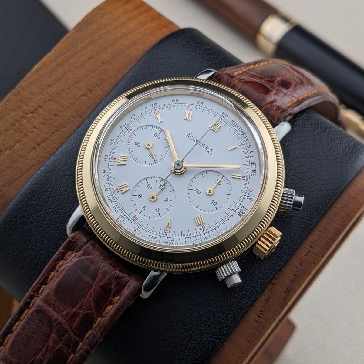 Close view of the Eberhard & Co. Godron Chrono reference 32031, showing its white dial, gold-tone markers, three subdials and brown strap.