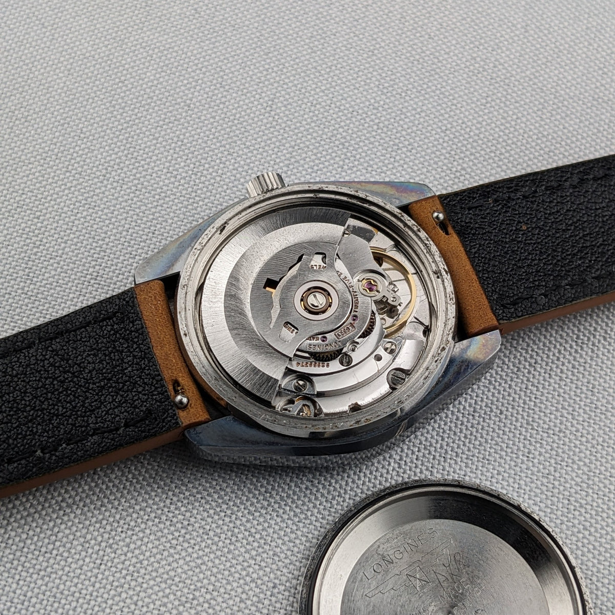 Close view of the exposed movement inside the LONGINES Automatic reference 3042-633, with the detached caseback beside it.