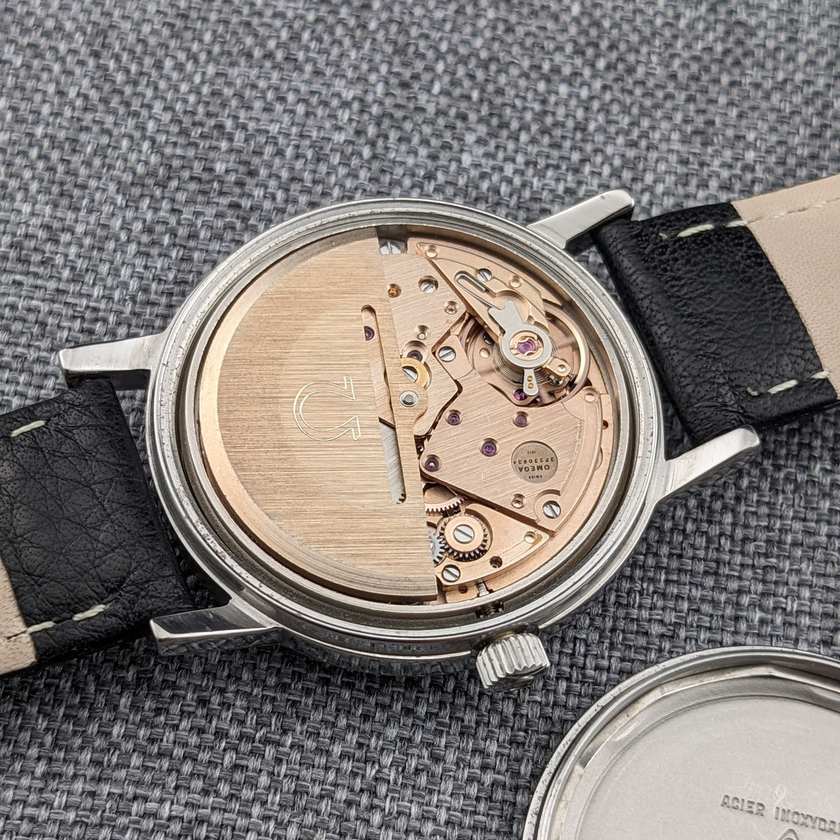 Omega Geneve Automatic reference 166.0163 opened to reveal its copper-toned mechanical movement, rotor, gears and jewel details.