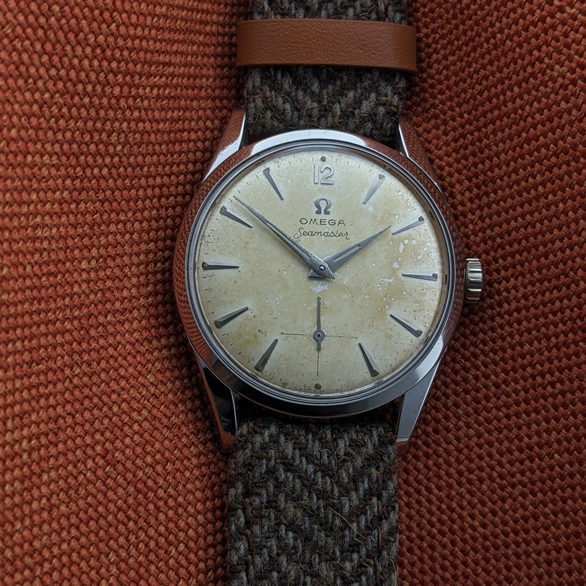 Front-facing Omega Seamaster reference 29374 with cream dial, Arabic 12, baton markers, central hands, seconds subdial and textured strap.