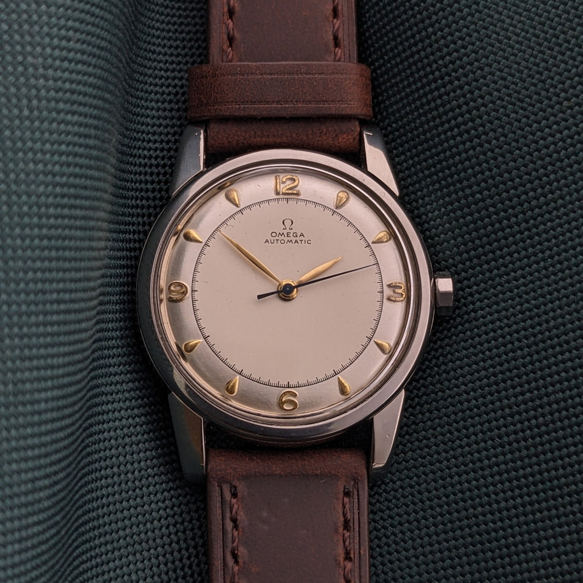 Front-facing Omega Automatic Bumper reference 2767-4 SC with cream dial, gold-tone markers, three hands and brown leather strap.