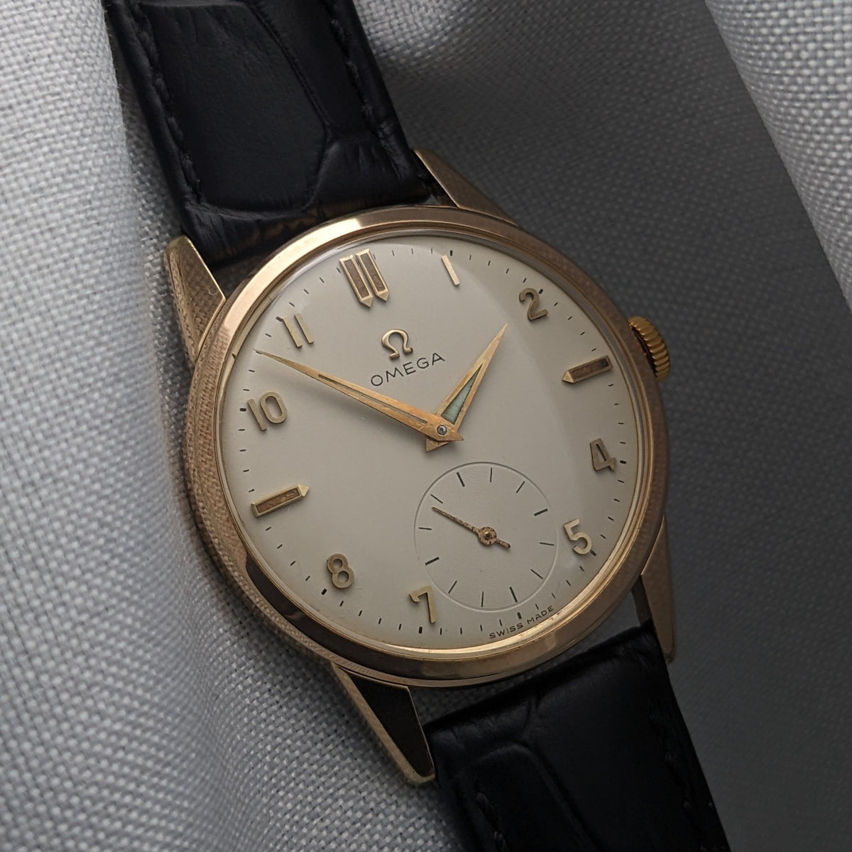 Close view of the Omega Classic reference 14391-1 dial, with gold-tone markers, central hands, small seconds and black crocodile-pattern strap.