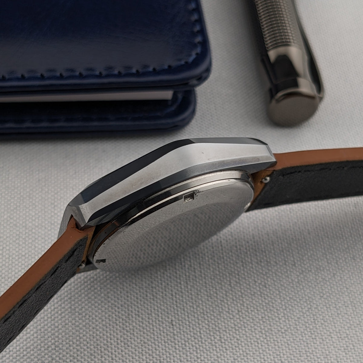 Side composition of the LONGINES Automatic reference 3042-633 showing its faceted case, crown, caseback edge and leather strap.