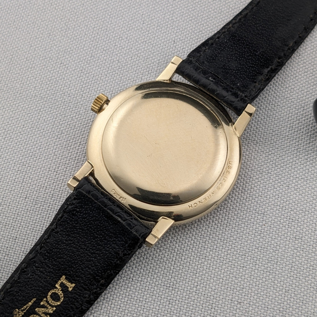 Rear view of the Longines Ultra-Chron reference 69-556AC showing the plain gold-tone caseback, lugs, crown, and black strap.