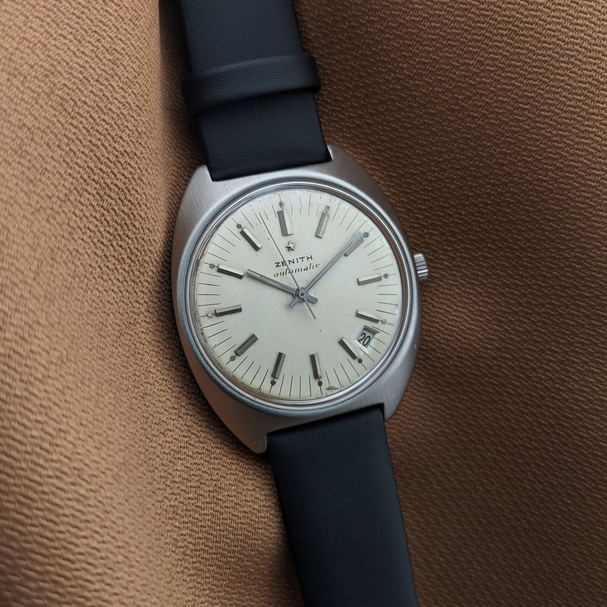 Zenith Automatic reference GR 720001 displayed vertically, showing its light dial, baton markers, date aperture, and black strap.