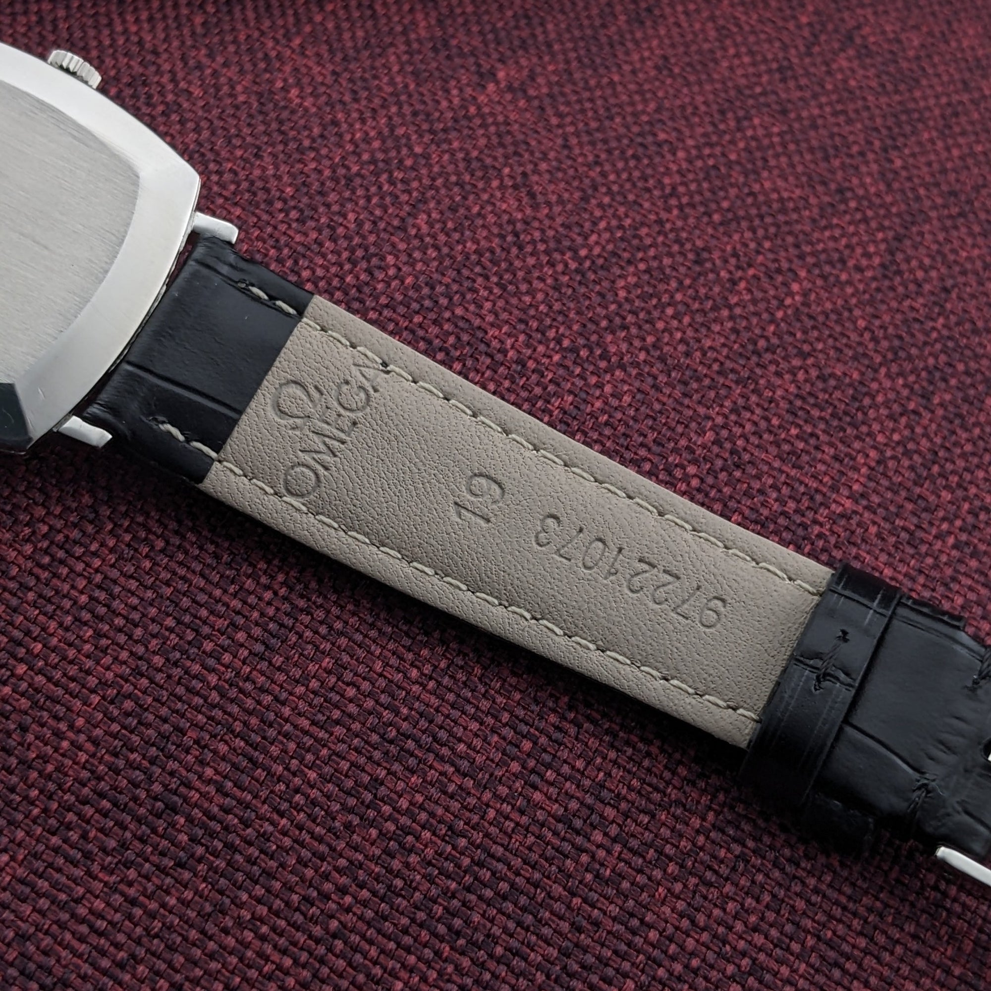 Reverse of the Omega Genève reference 131.022 strap, showing the light lining with embossed Omega branding and reference markings.