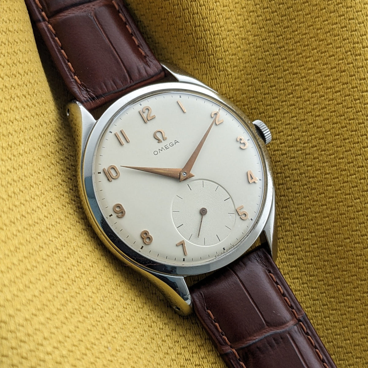 Nahaufnahme des Omega Jumbo Referenz 2505-10 Zifferblatts mit goldfarbenen arabischen Ziffern, zentralen Zeigern und kleiner Sekunde.