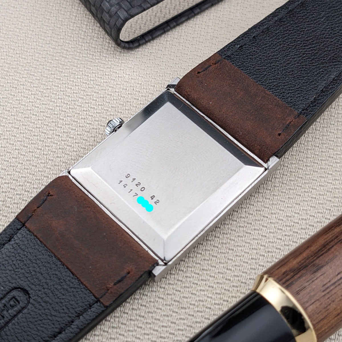 Rückansicht der Jaeger-LeCoultre Vogue Tank Ref. 9120 zeigt ein graviertes rechteckiges Gehäuse, braune Armbandabschnitte und ein strukturiertes Gehäuse.