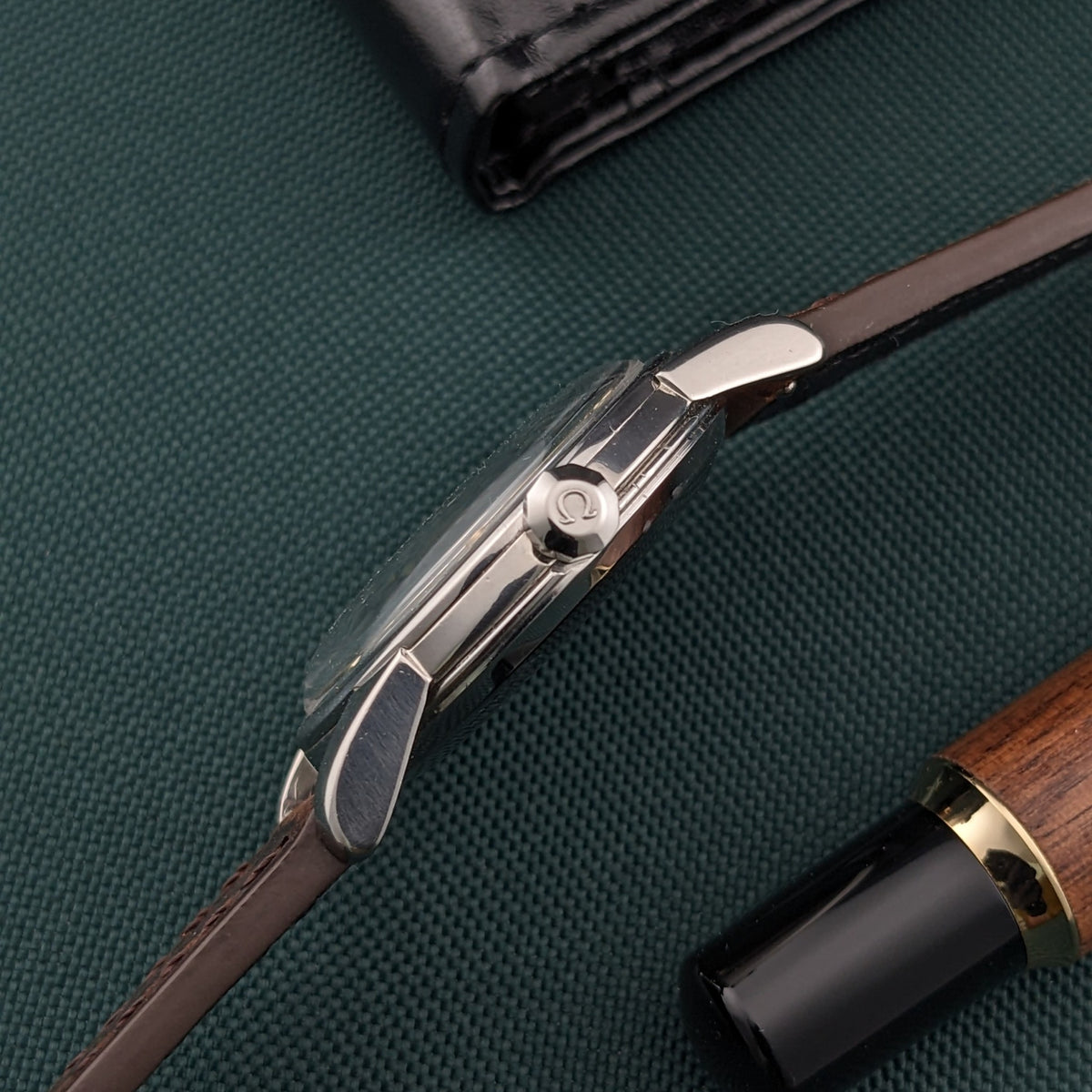 Side view of the Omega Automatic Bumper reference 2767-4 SC showing its case profile, lugs, crown and slim brown leather strap.