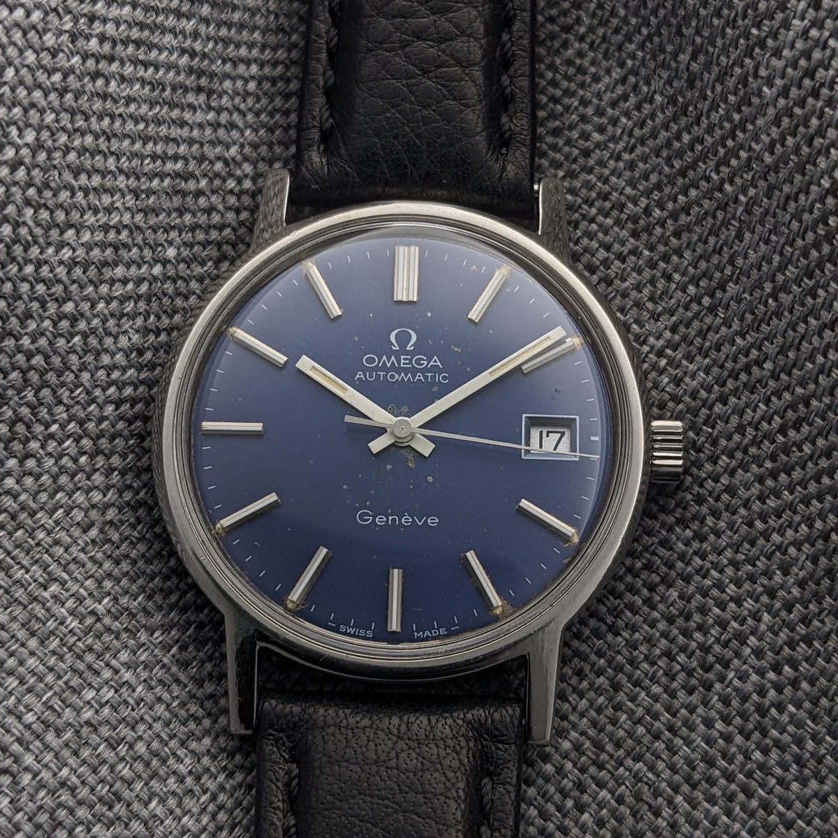 Front-facing Omega Geneve Automatic reference 166.0163 with blue dial, silver baton markers, date window and black leather strap.