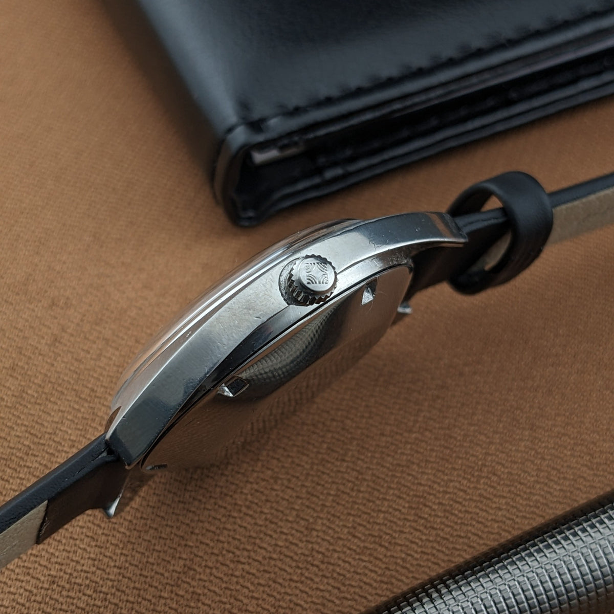 Side profile of the Zenith Automatic reference GR 720001 showing the crown, case edge, black strap, and black case behind it.