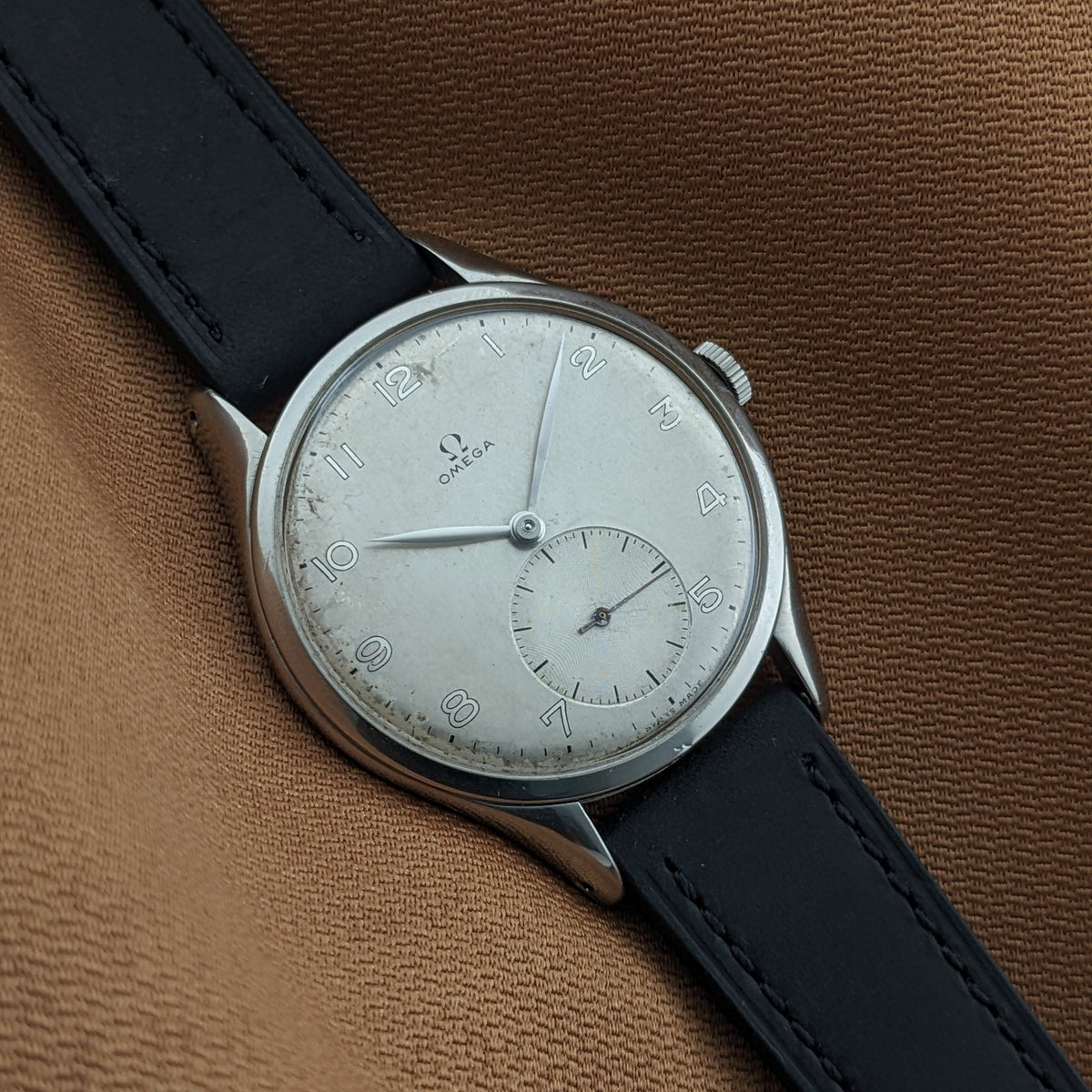 Angled close-up of the Omega Jumbo reference 2505-5, showing the silver-toned dial, Arabic numerals, small seconds, and black strap.