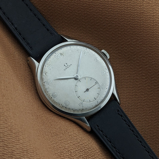 Angled close-up of the Omega Jumbo reference 2505-5, showing the silver-toned dial, Arabic numerals, small seconds, and black strap.