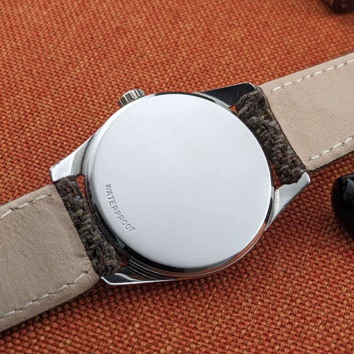 Omega Seamaster reference 29374 viewed from the rear with a smooth circular caseback, leather underside strap and crown visible at the top.
