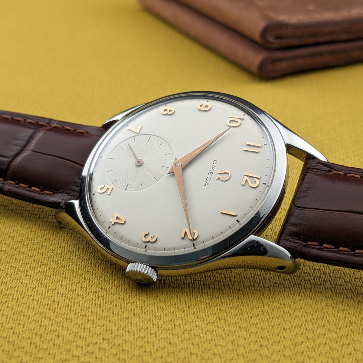 Schrägansicht des Omega Jumbo Referenz 2505-10, hebt das gewölbte Glas, das schlanke Gehäuseprofil, die Krone und das braune Lederarmband hervor.