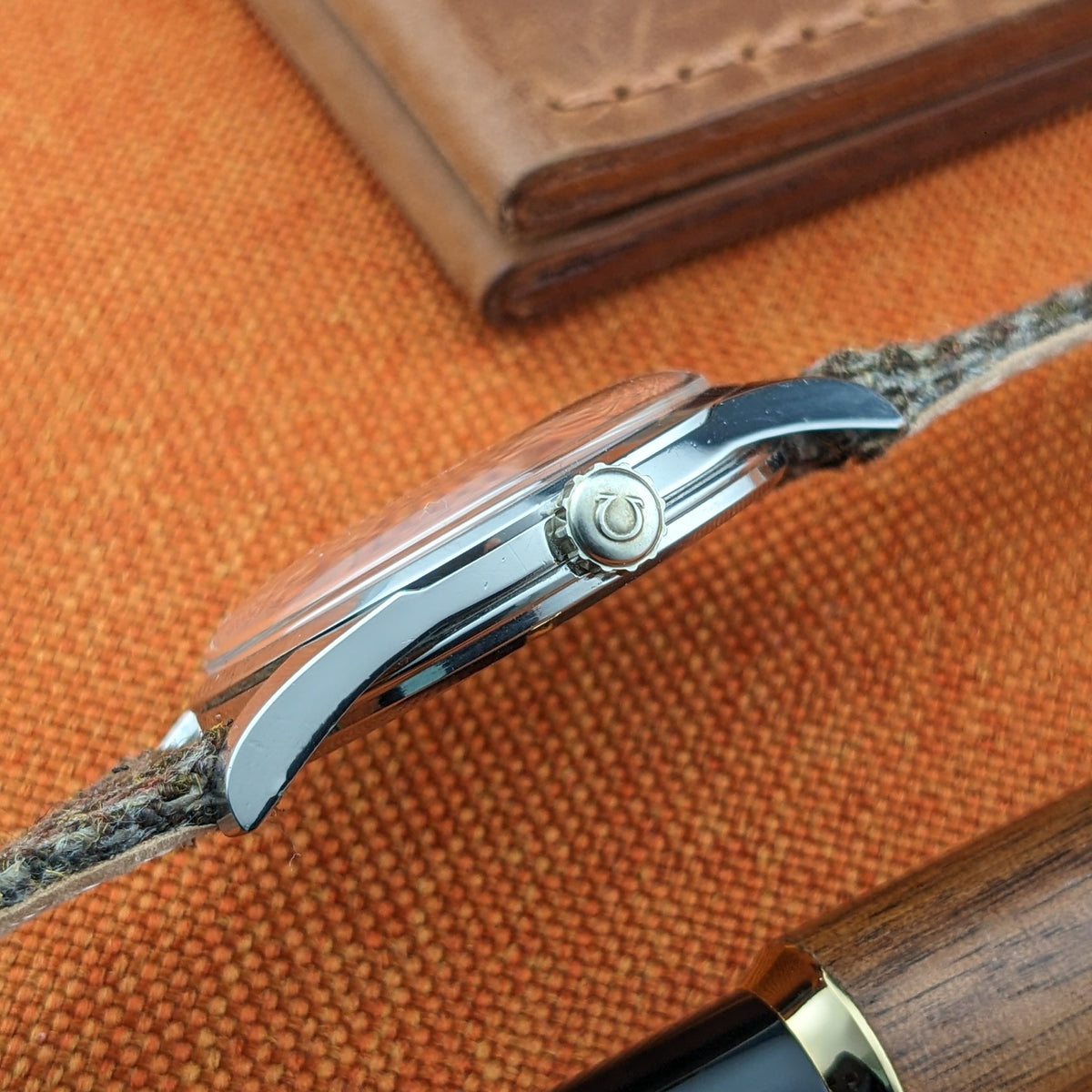 Side profile of the Omega Seamaster reference 29374, showing the polished case edge, domed crystal profile, winding crown and woven strap.