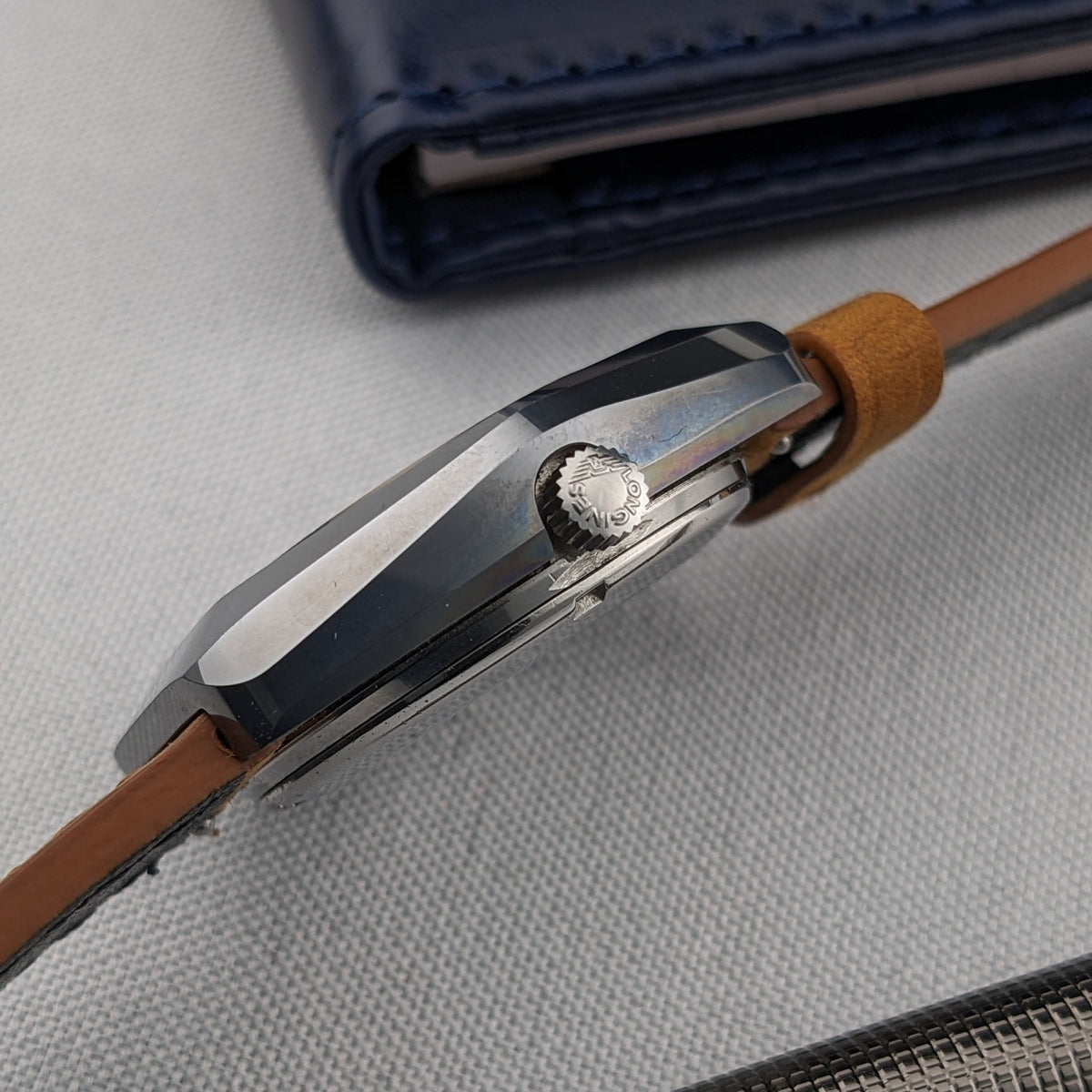 Close side view of the LONGINES Automatic reference 3042-633 highlighting the signed crown, faceted case and brown leather strap.