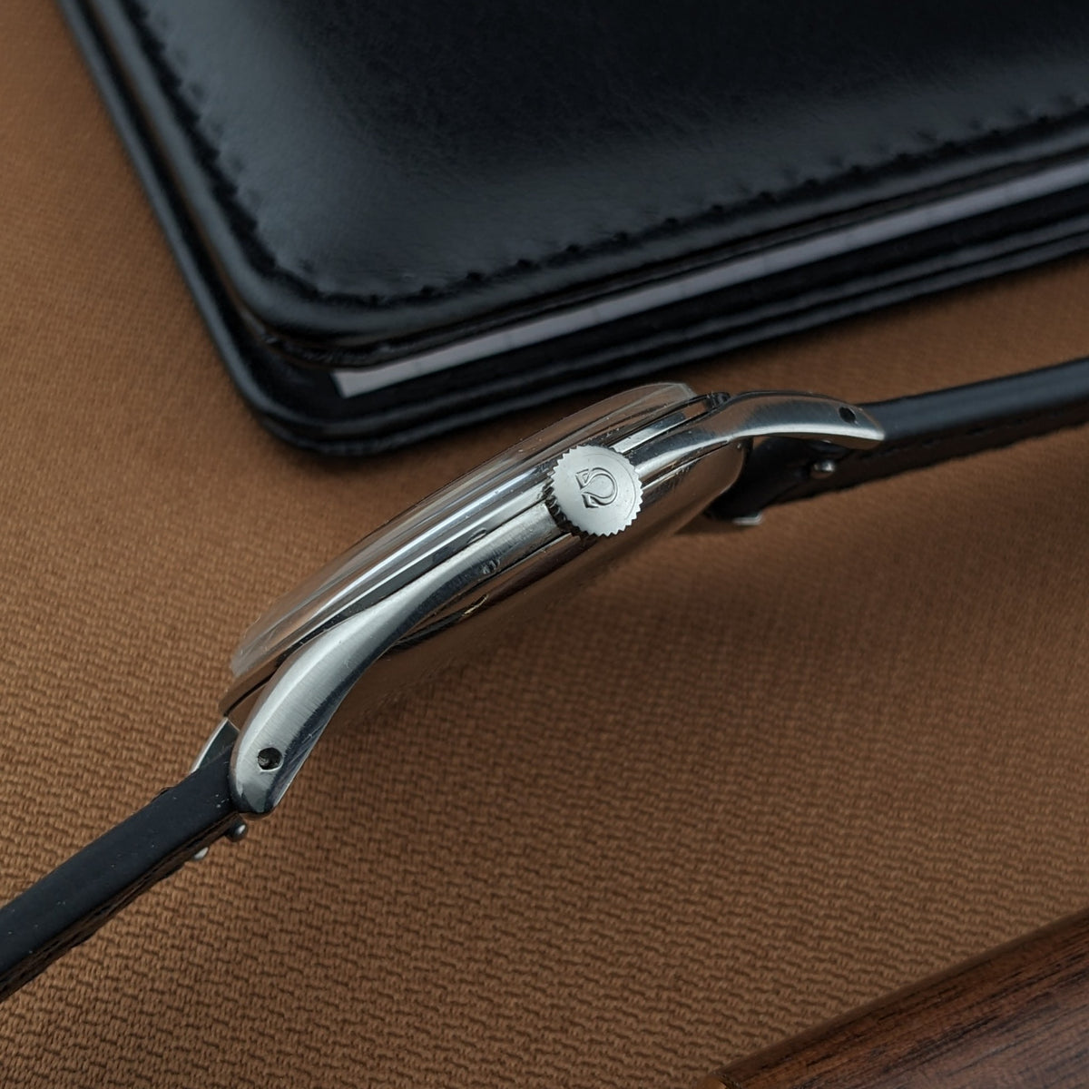 Side profile of the Omega Jumbo reference 2505-5 highlighting the Omega-marked crown, slim case, lugs, and black leather strap.