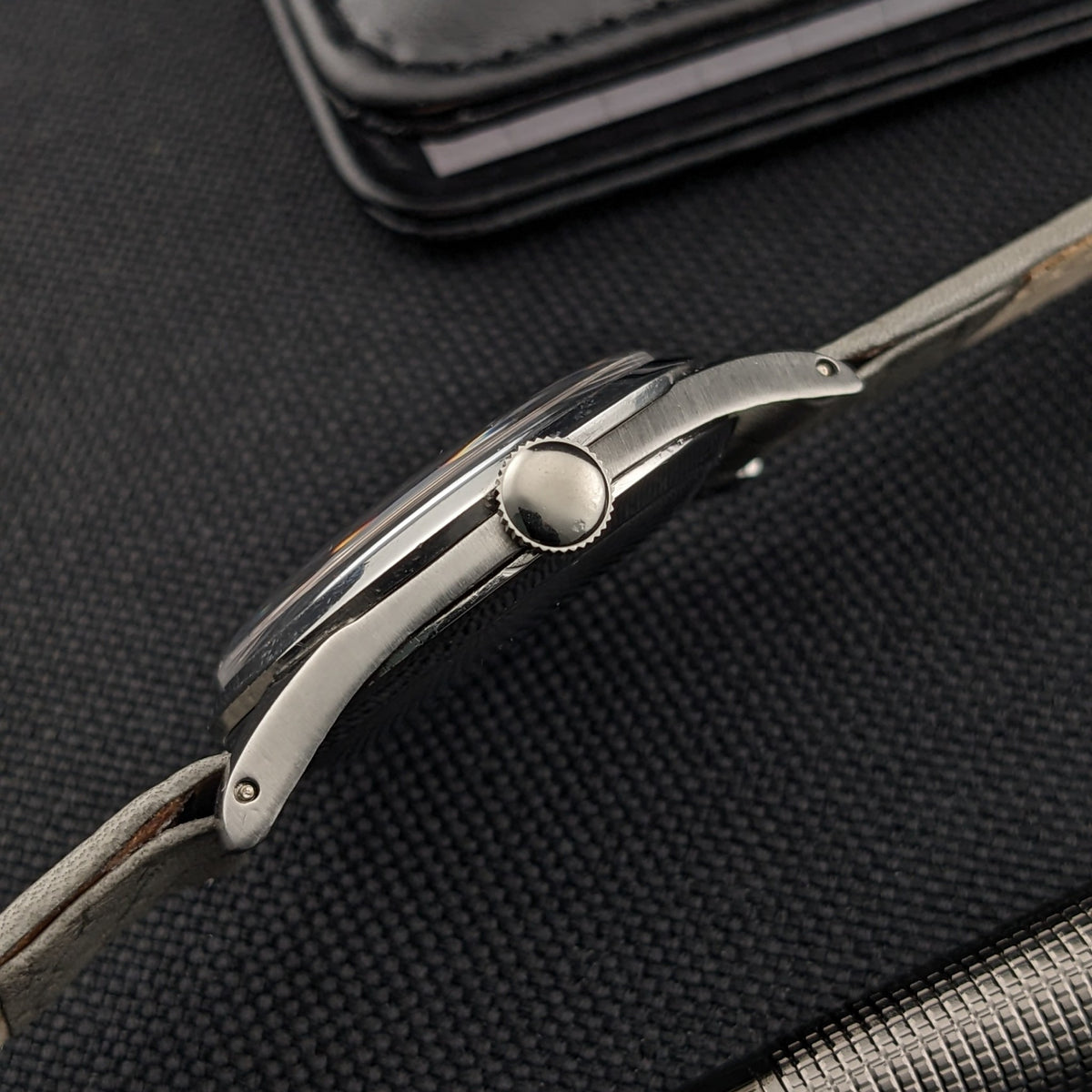 Omega Classic Referenz 2760-6 SC im Seitenprofil, mit rundem Gehäuse, geriffelter Krone, Bandanstößen und grauem Armband sichtbar.