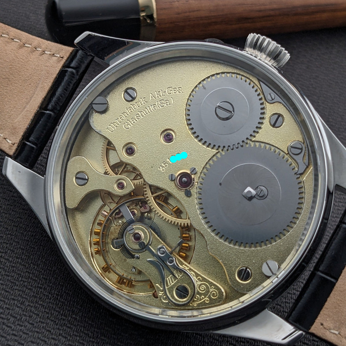 Nahaufnahme des Deutsche Präzisions-Uhrenfabrik Glashütte Uhrwerks mit großen Zahnrädern und gravierter Referenz 351960.