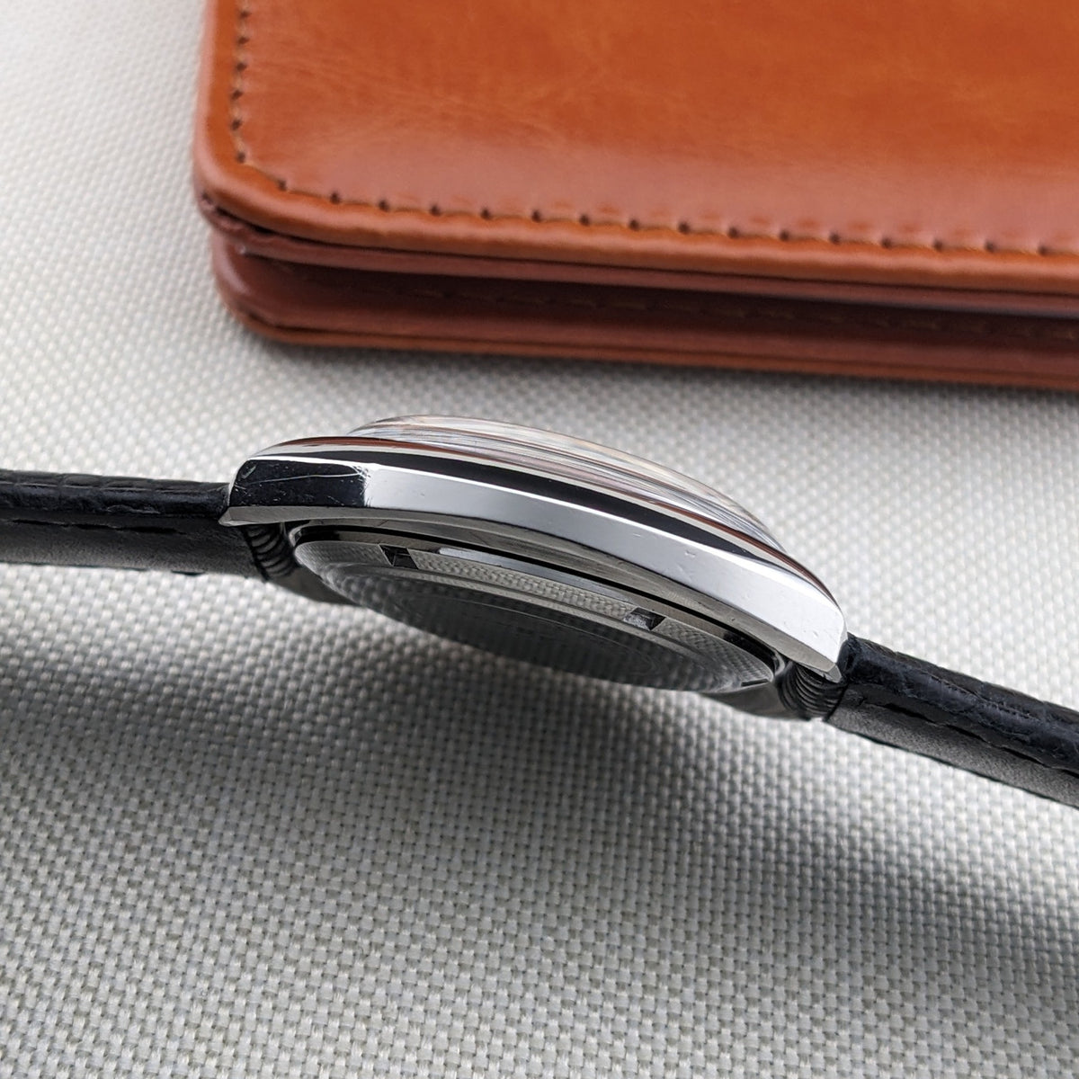 Low side view of the Longines Ultrachron reference 8429 showing the case profile, crystal, caseback edge and black strap.