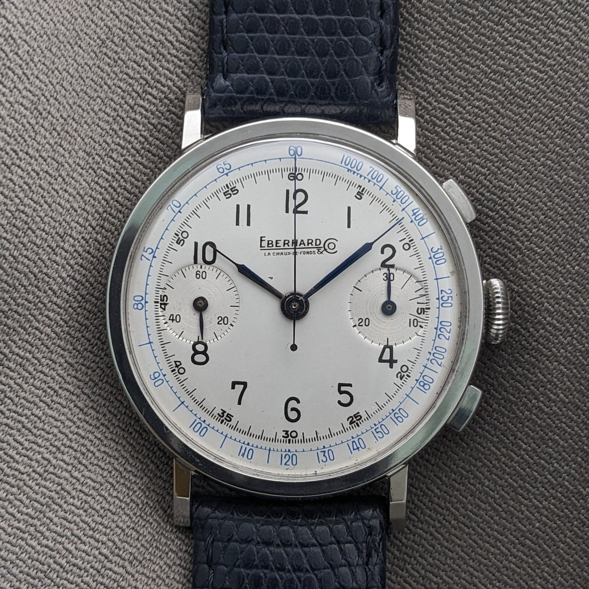 Straight-on Eberhard & Co. Pre-Extra Fort presentation showing the cream dial, blue tachymeter markings, two subdials and textured strap.