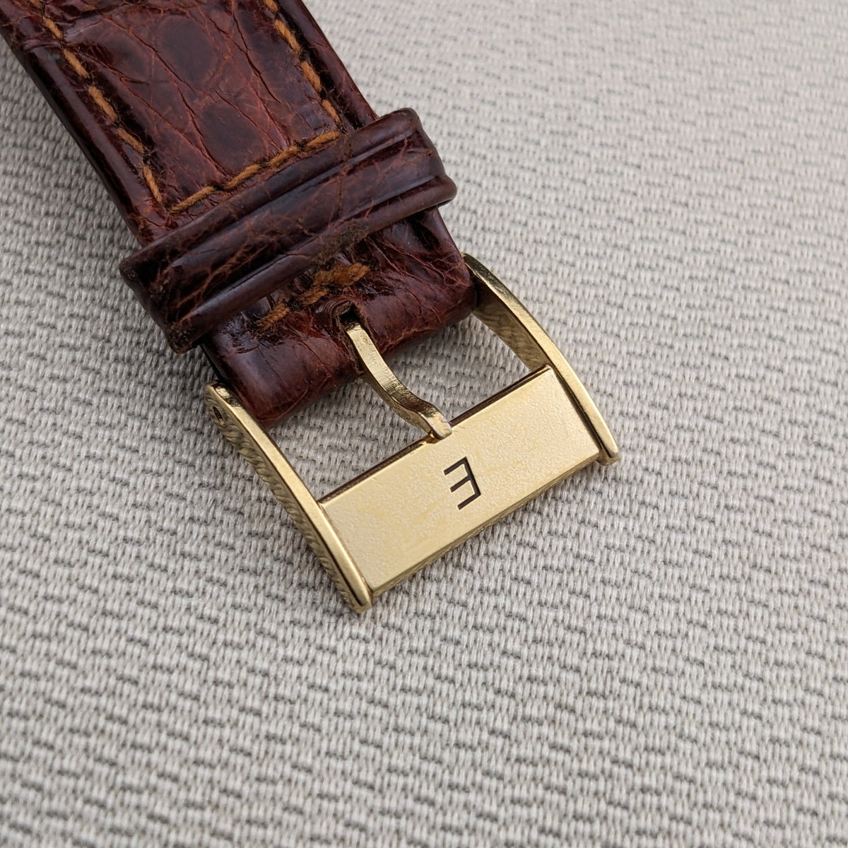 Close-up of the brown strap and gold-tone Eberhard & Co. buckle from the Godron Chrono reference 32031.