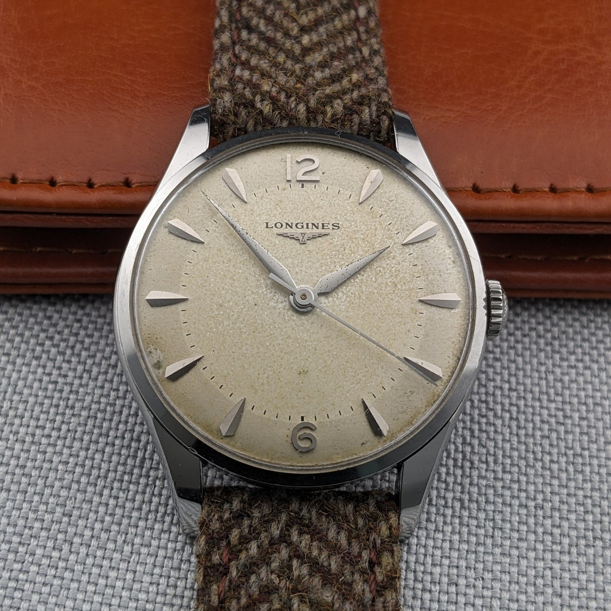 Straight-on view of the Longines Classic reference 8135-5 showing the cream dial, 12 and 6 numerals, applied markers and brown woven strap.