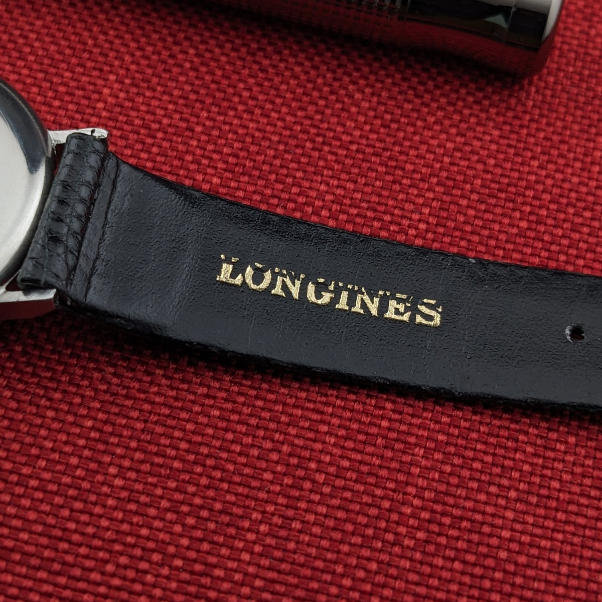 Longines Calatrava reference 20757 black strap shown from the underside, with gold Longines lettering visible beside the round case edge.