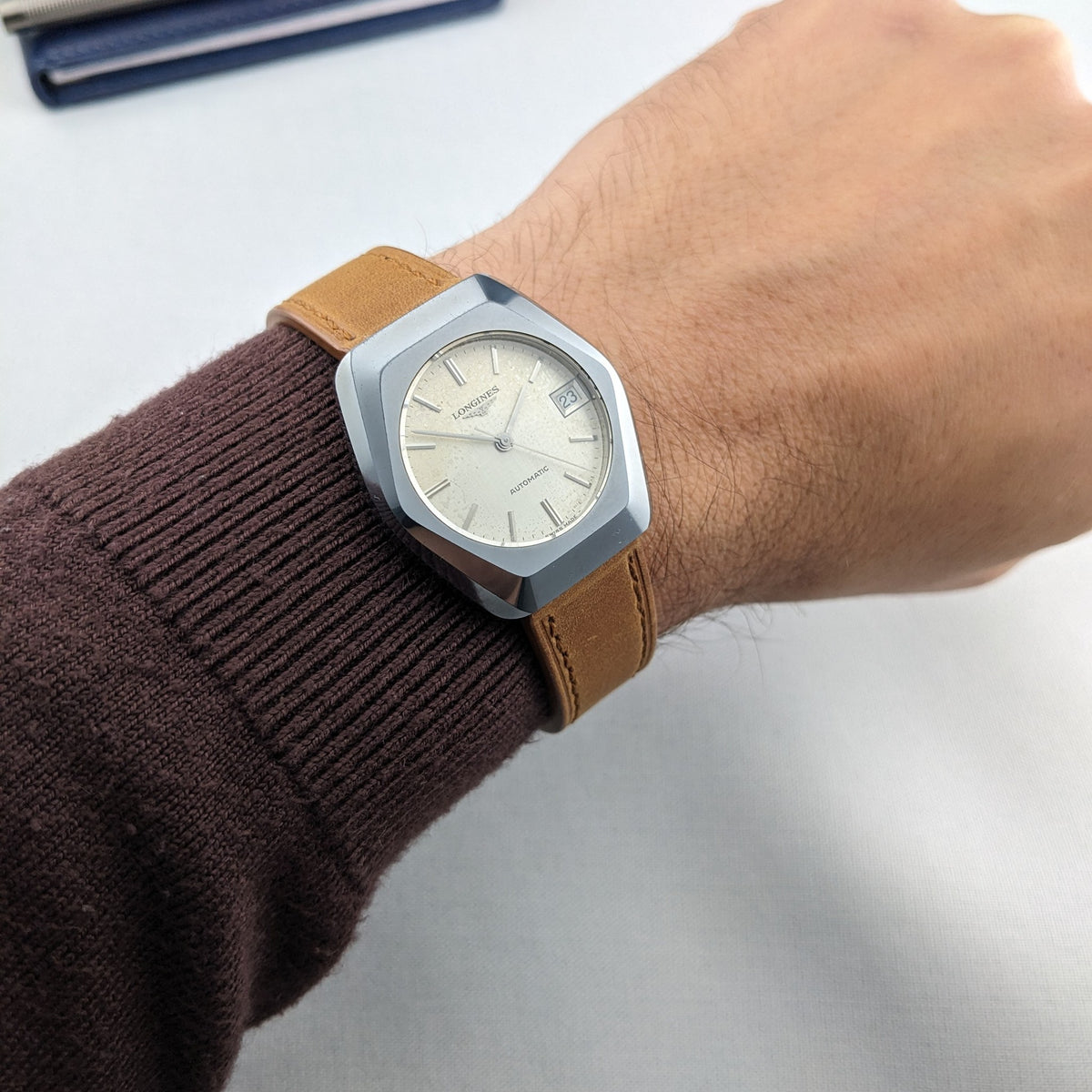 Angled wrist composition featuring the LONGINES Automatic reference 3042-633 with a faceted case, cream dial and tan strap.