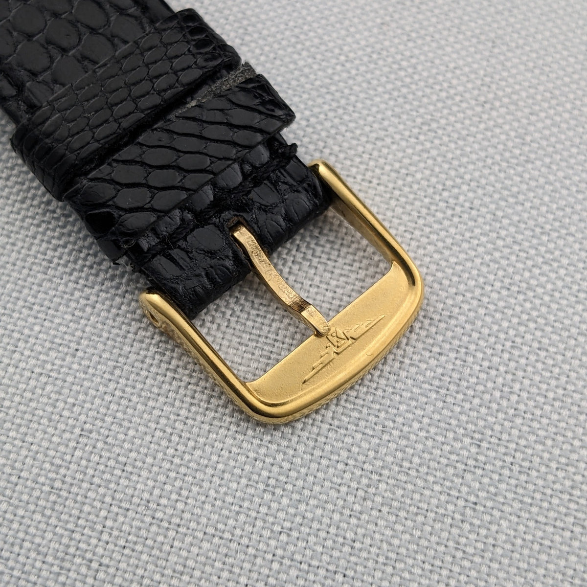Detailed view of the gold-tone buckle and textured black strap of the Longines Ultra-Chron reference 69-556AC.