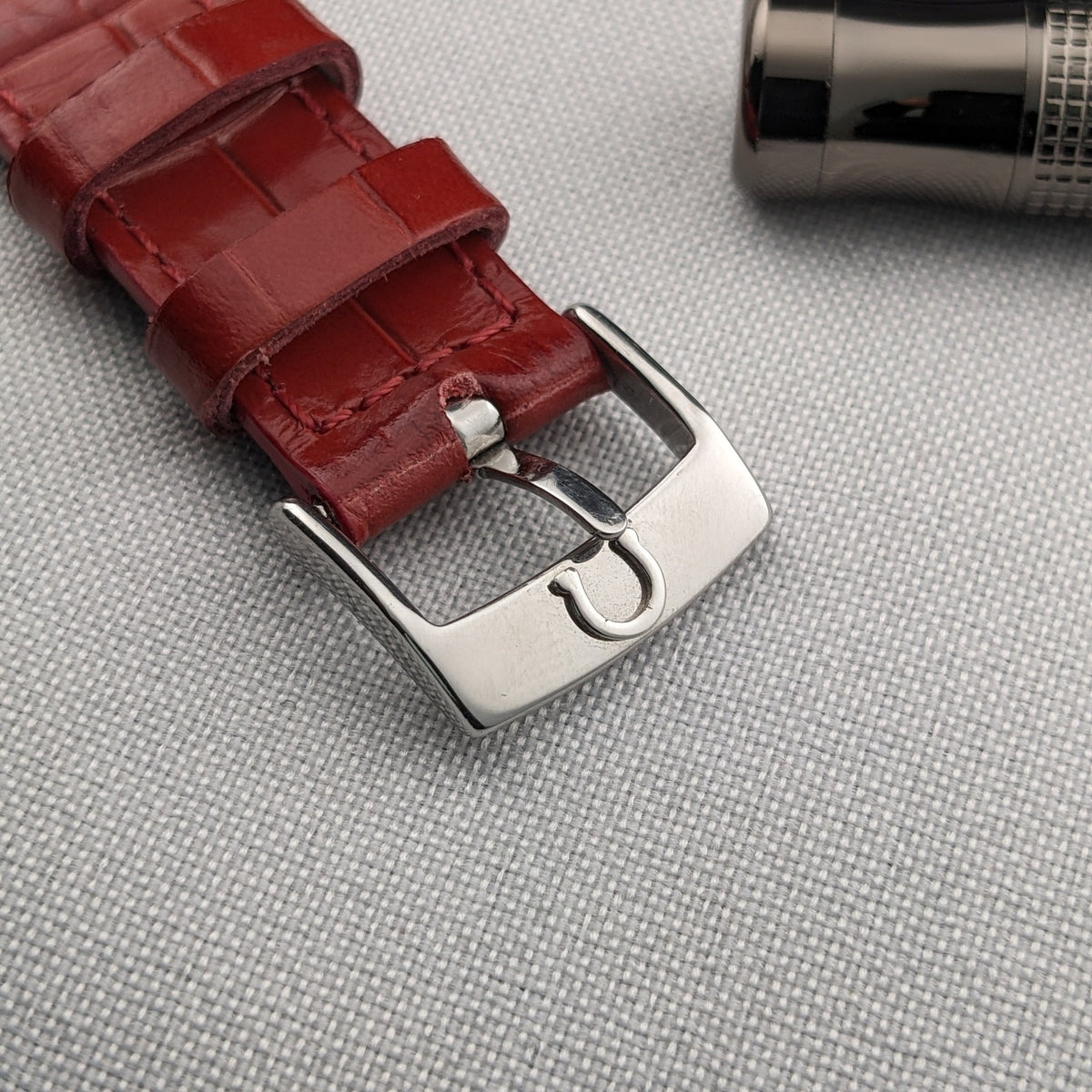 Close-up of the red strap and silver Omega buckle associated with the Constellation Quadra 1841.73.31.