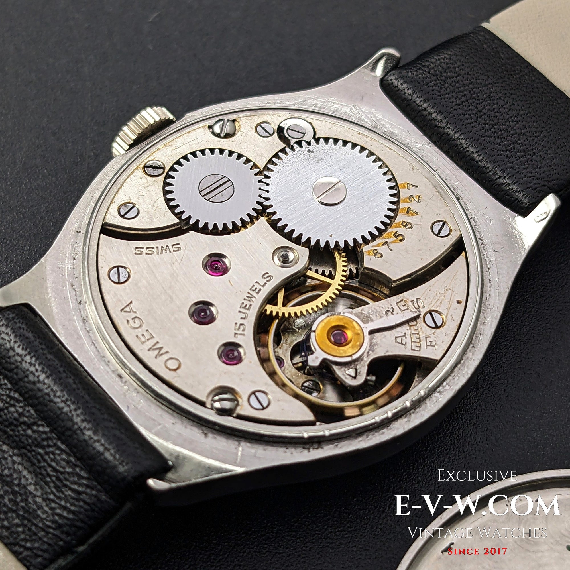 Close-up of the Omega Cal. 26.5SOBT2 movement, revealing intricate gears and 15-jewel mechanism inside the vintage 1935 steel wristwatch.