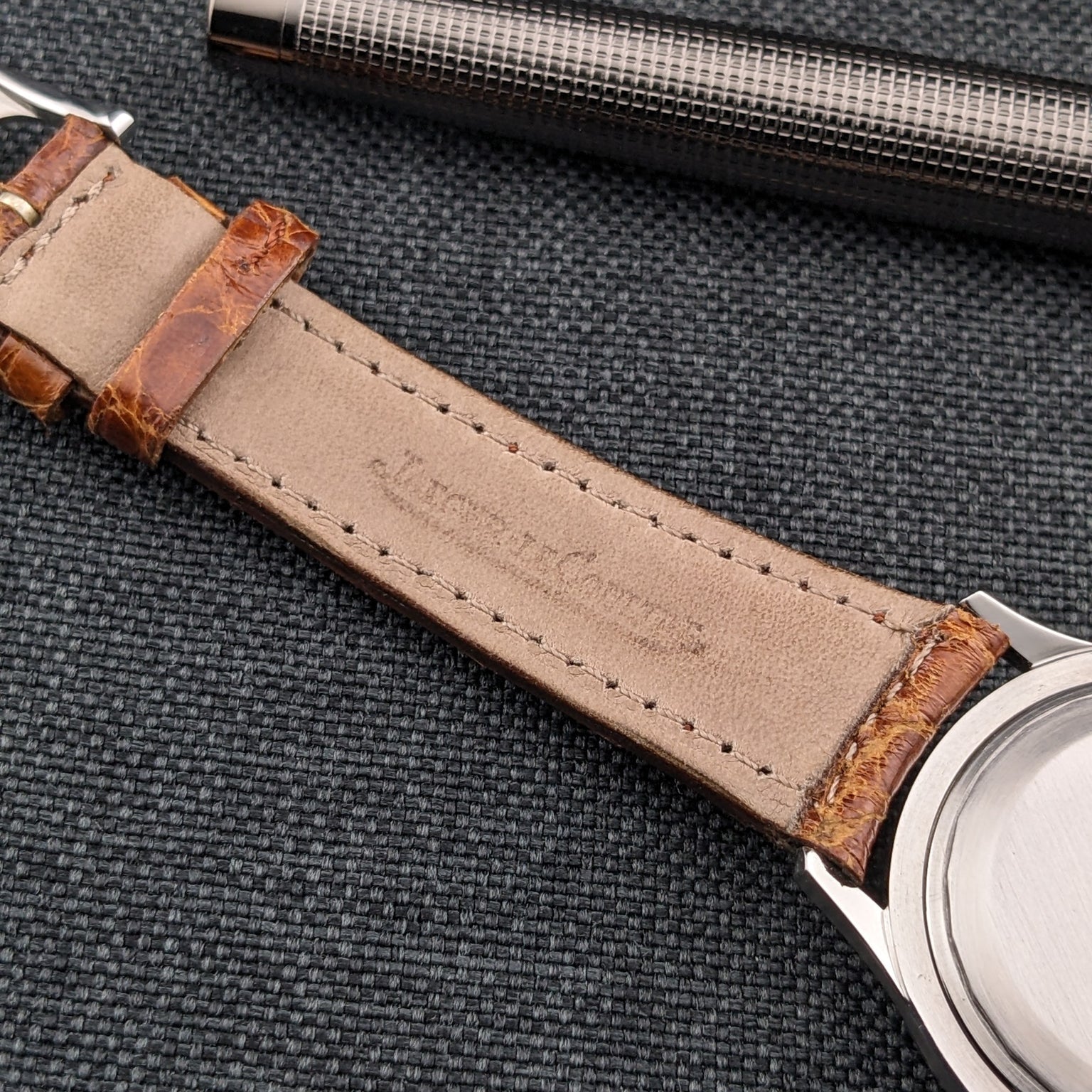 Rear view of the Jaeger-LeCoultre Automatic E328 with a plain circular caseback and light underside of the brown strap.